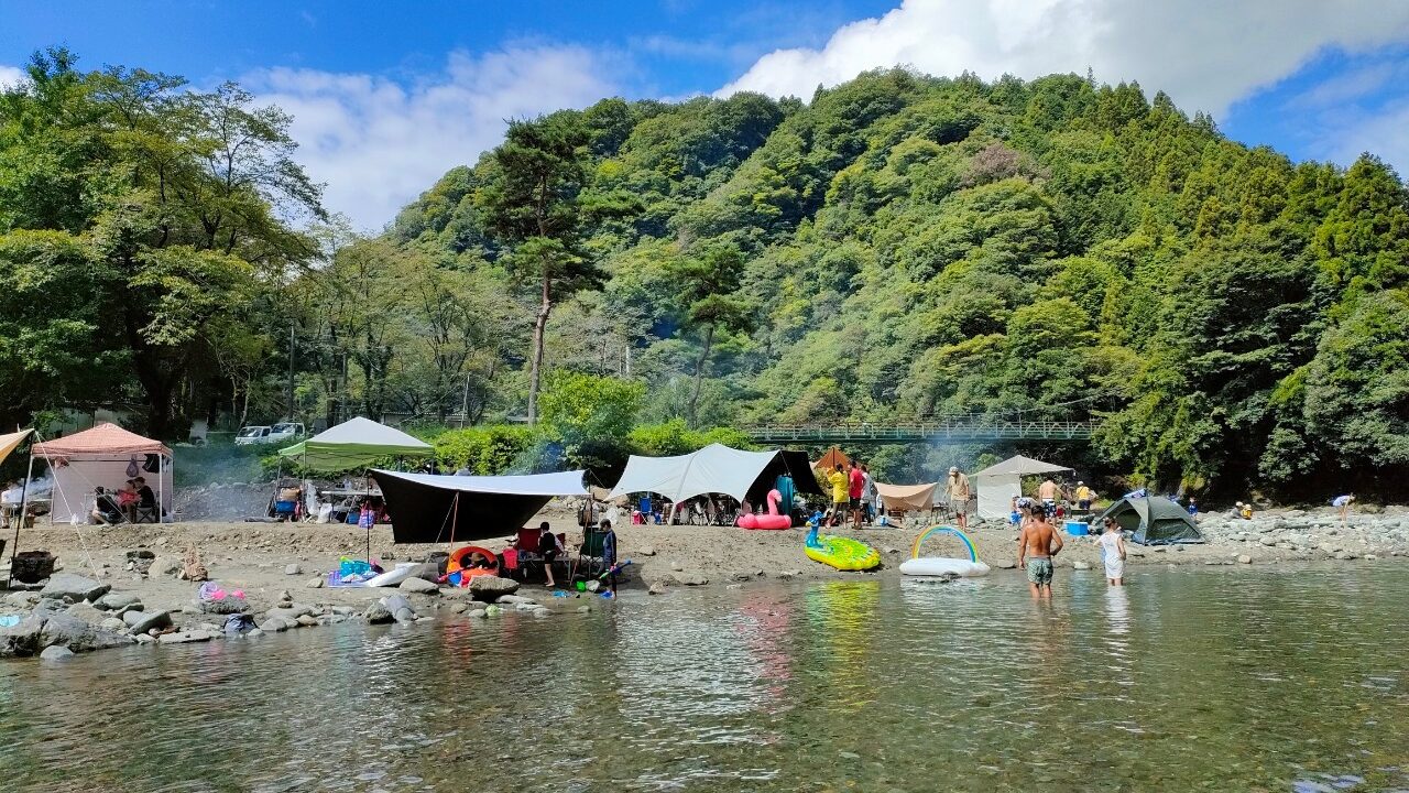 青野原オートキャンプ場で川遊び、後ろに道志川と橋がかかる